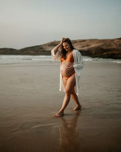 Joana Fleck grávida, caminhando na praia
